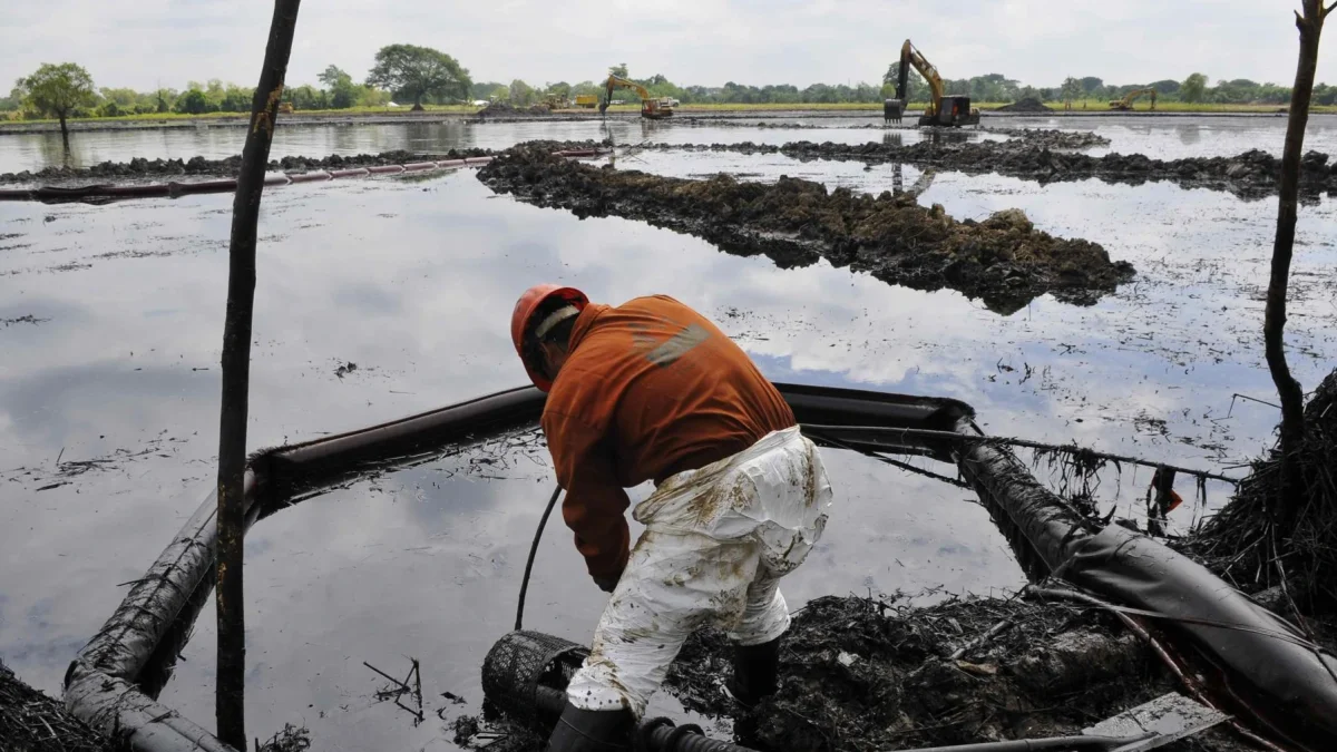 Fotografía de referencia de un empleado de la estatal Petróleos Mexicanos (Pemex) en medio de una extracción de crudo vertido durante un derrame de combustible.
