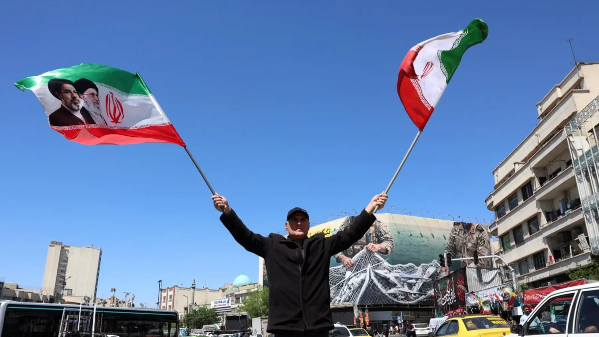 Un hombre ondea este miércoles 22 de abril de 2026, banderas iraníes en Teherán.