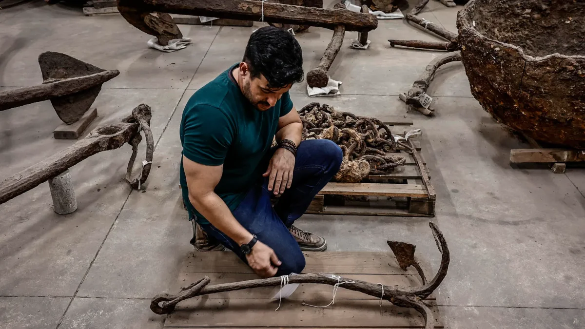 El arqueólogo Enrique Vences,observando varios tipos de anclas y otros equipos navales hallados en las excavaciones del Muelle de Valongo, en Río de Janeiro (Brasil).