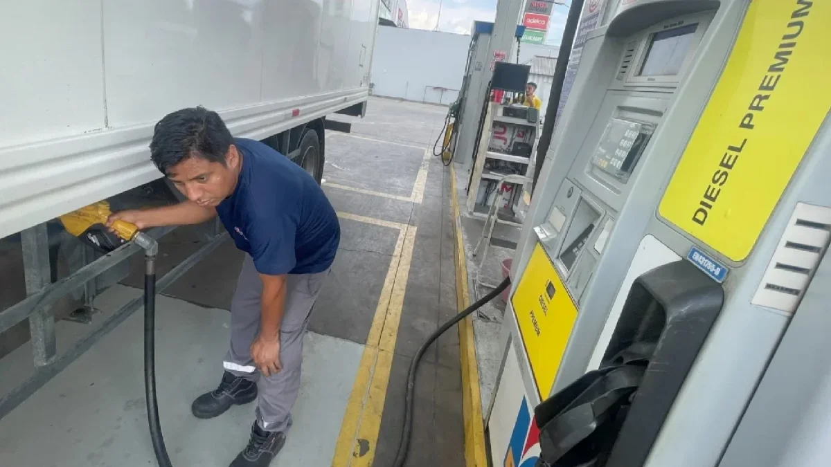 Trabajador carga diésel premium en camión en una gasolinera de Ecuador