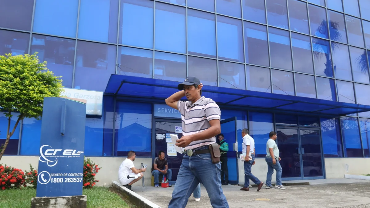 Una persona camina al pie de la empresa eléctrica en Guayaquil.