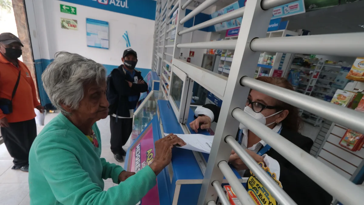 Una mujer de la tercera edad muestra una receta médica para comprar fármacos.