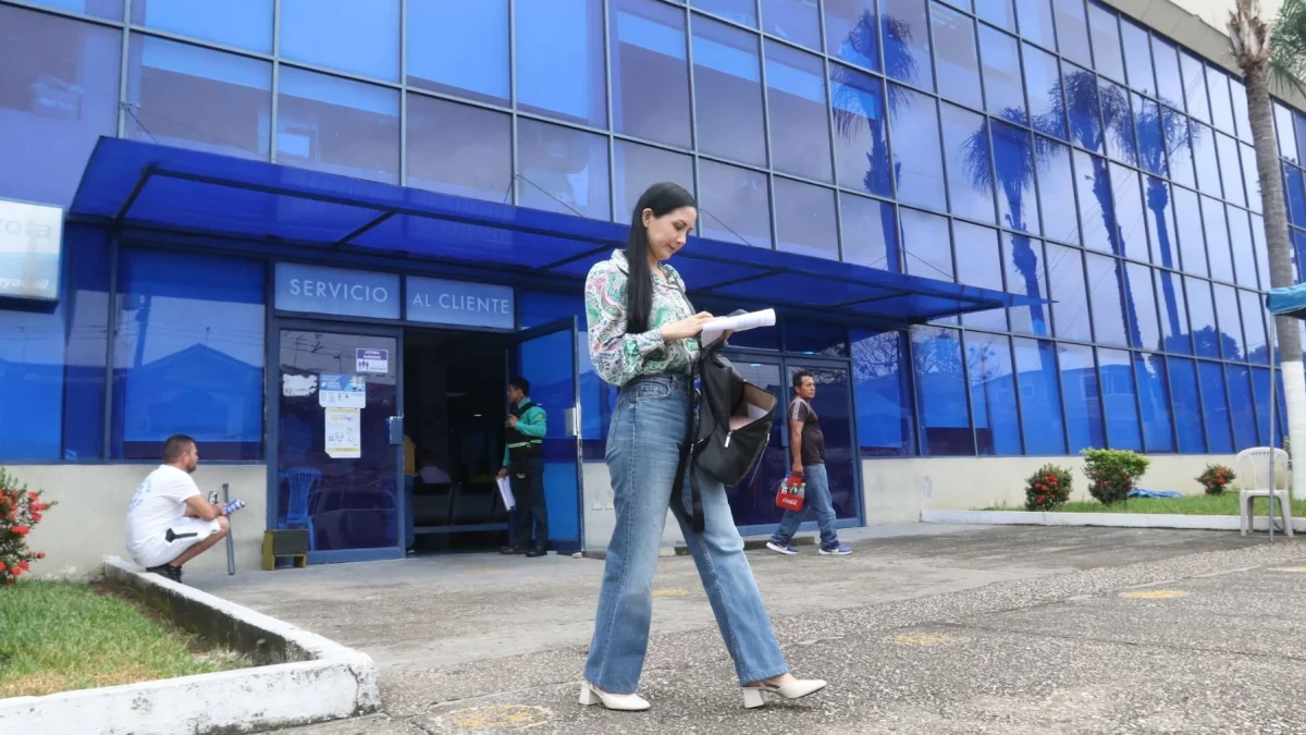 Una persona camina al pie de la empresa eléctrica en Guayaquil