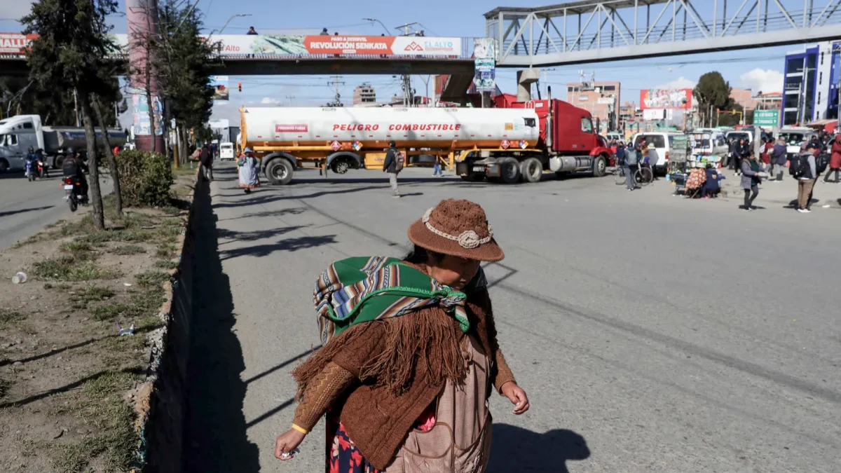 Una mujer aimara camina frente a un camión durante una jornada de protestas este lunes, en El Alto (Bolivia).