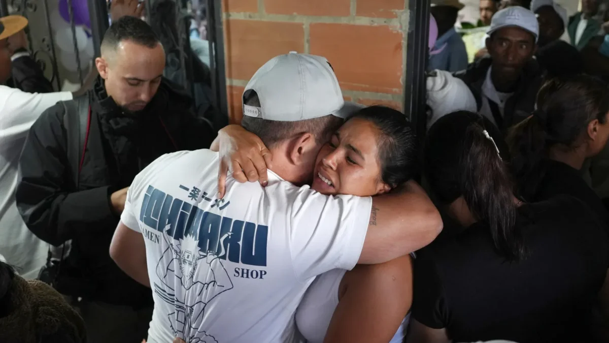 Personas se abrazan durante un velorio por las víctimas mortales de la explosión de un cilindro bomba en Cajibío (Colombia).