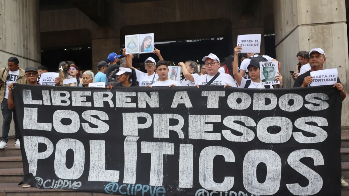 Personas sostienen carteles como parte de una manifestación para denunciar la situación de los presos políticos en cárceles de Venezuela este lunes, en Caracas (Venezuela).
