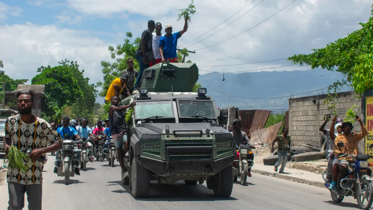 Personas celebran la llegada de la Policía Nacional Haitiana (PNH) a una zona del barrio Cité Soleil tras enfrentamientos entre grupos armados, en Puerto Príncipe (Haití).