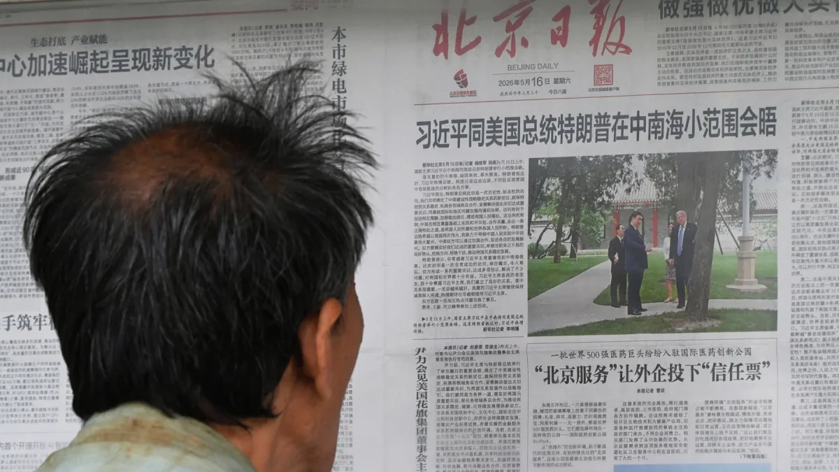 Un hombre lee un periódico en Pekín sobre la visita de Donald Trump a Xi Jinping.