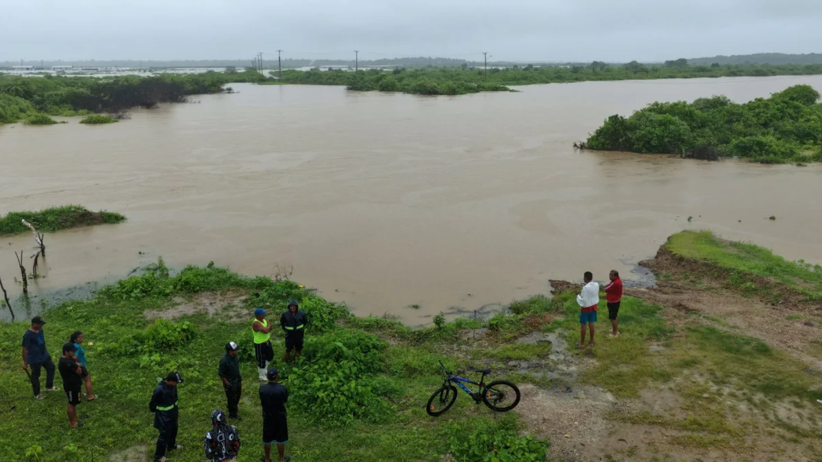 Fotografía de archivo que muestra a personas observando las inundaciones en la localidad de Chanduy en Santa Elena.