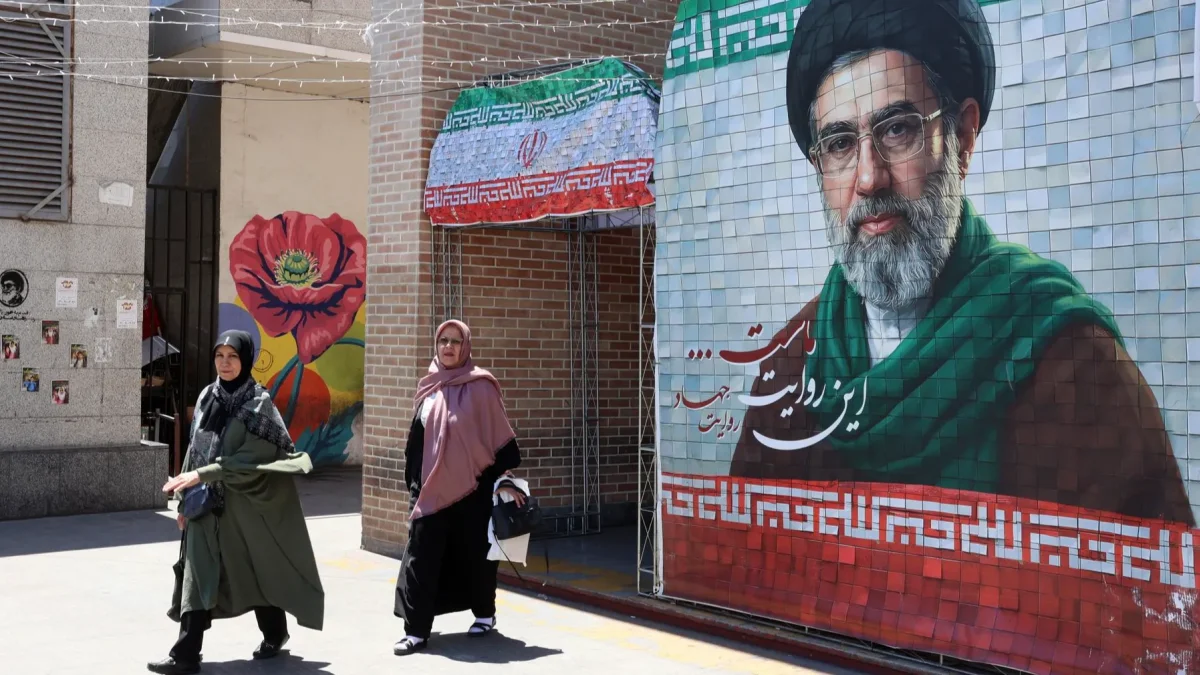 Ciudadanas iraníes pasan junto a una fotografía del líder supremo iraní, el ayatolá Mojtaba Khamenei, en una calle de Teherán, Irán, el 18 de mayo de 2026.