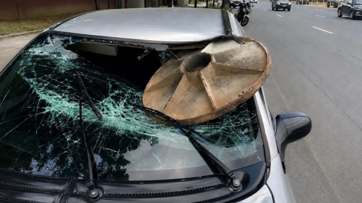 La tapa de la alcantarilla se incrustró en el parabrisas del automóvil, sobre el lado del conductor, quien recibió atención médica.