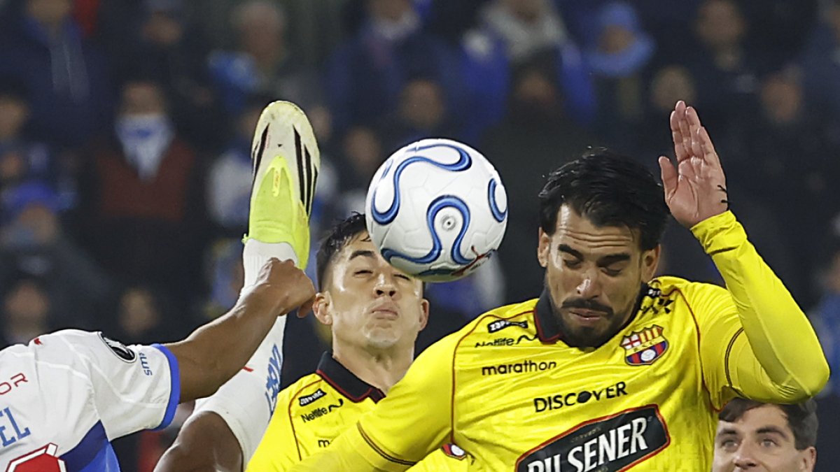 Juan Francisco Rossel (i) de Católica disputa el balón con Cristian Báez de Barcelona en el partido donde el equipo chileno eliminó a los canarios de Copa Libertadores.