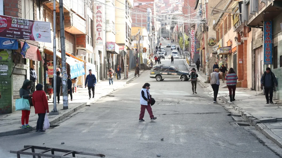 Personas caminan por una vía cerrada durante una jornada de bloqueos por parte de transportistas este martes, en La Paz (Bolivia).