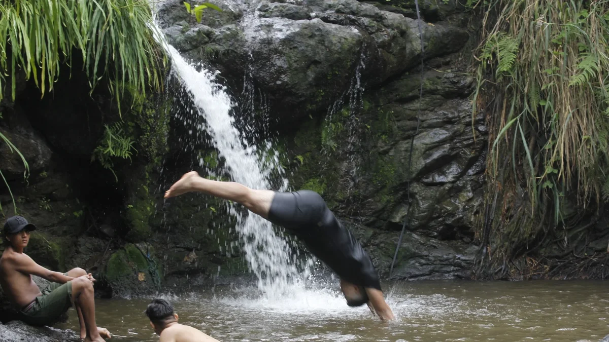 Jóvenes se bañan en una pequeña cascada en el cerro Azul de Guayaquil.