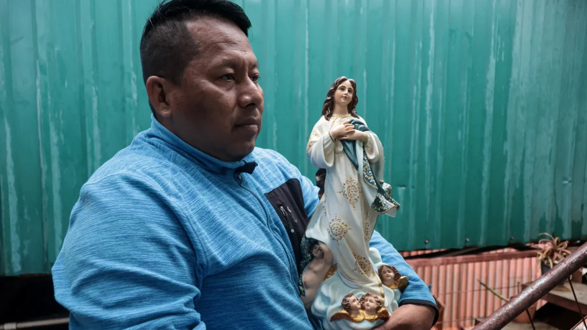 El maestro nicaragüense exiliado Gabriel Putoy sostiene una imagen religiosa durante una entrevista.