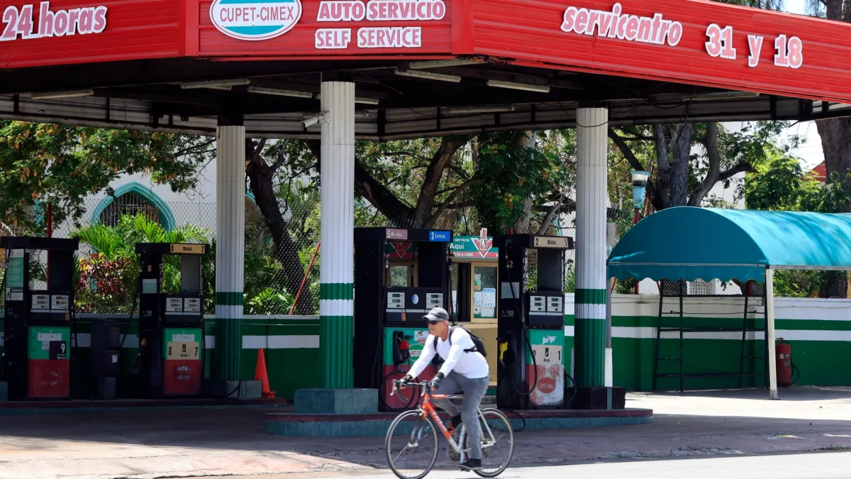 Una persona pasando en bicicleta frente a una estación de gasolina cerrada en La Habana (Cuba).