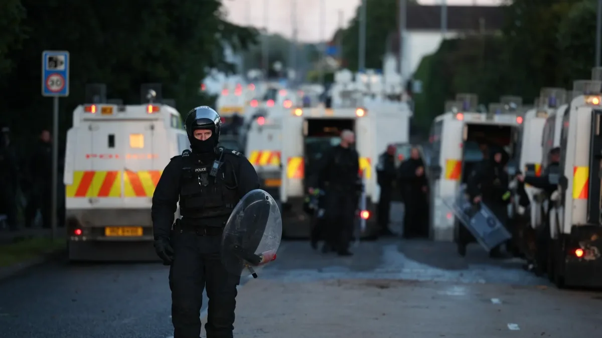 Un agente de policía camina con equipo antidisturbios en el lugar de los disturbios antiinmigración en Antrim Road en Newtownabbey, al norte de Belfast, Irlanda del Norte.