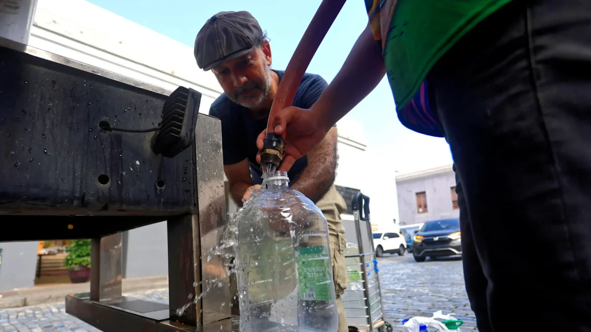 Personas se abastecen de agua tras la interrupción del servicio este lunes, en San Juan (Puerto Rico).
