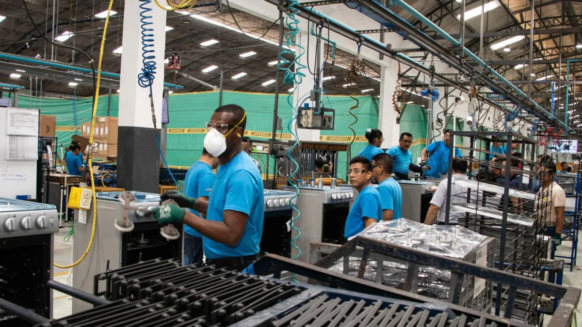 Un grupo de trabajadores cumple con su jornada laboral en una fábrica.