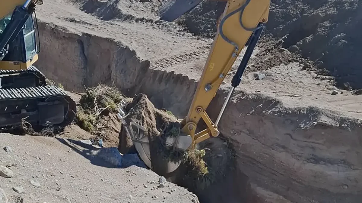 Una excavadora destruyendo un puente clandestino en una zanja de la frontera norte este martes, en Colchane (Chile).