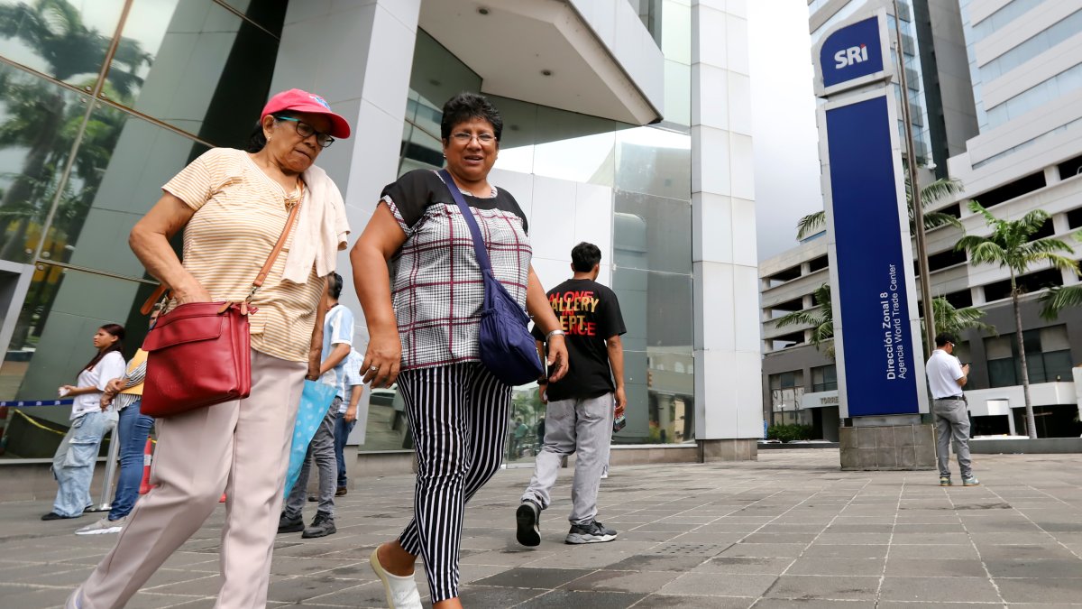 Ciudadanos saliendo del edificio del Servicio de Rentas Internas, en Guayaquil.