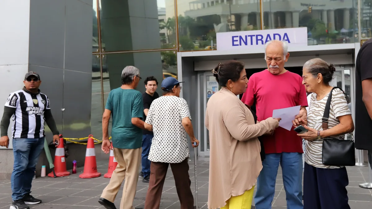 Adultos mayores en el exterior del edificio del Servicio de Rentas Internas, en Guayaquil.