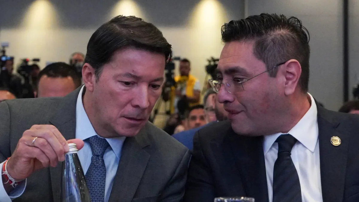 El registrador Hernán Penagos (i) y el presidente del Consejo Nacional Electoral (CNE), Cristian Quiroz, hablan durante la instalación de la Misión de Observación Internacional.