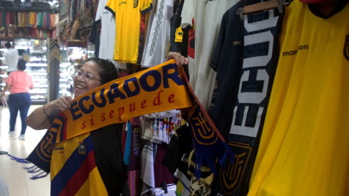 Una clienta sostiene una bufanda tricolor con el lema