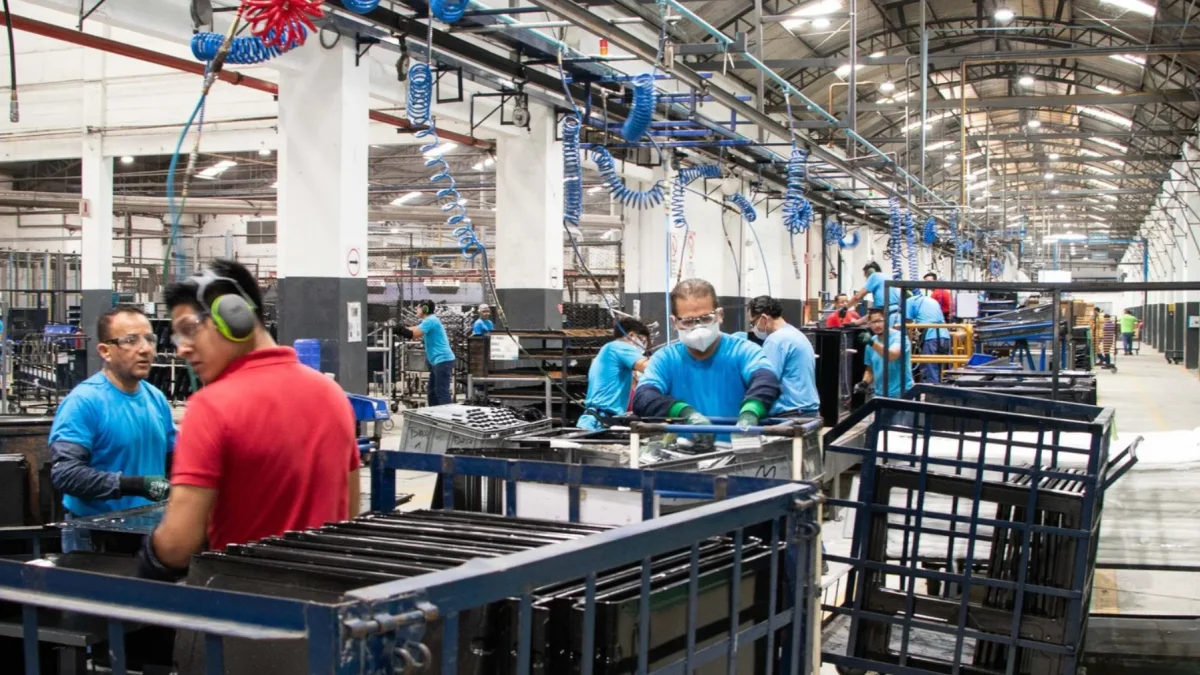Un grupo de trabajadores cumple con su jornada de trabajo en una fábrica.