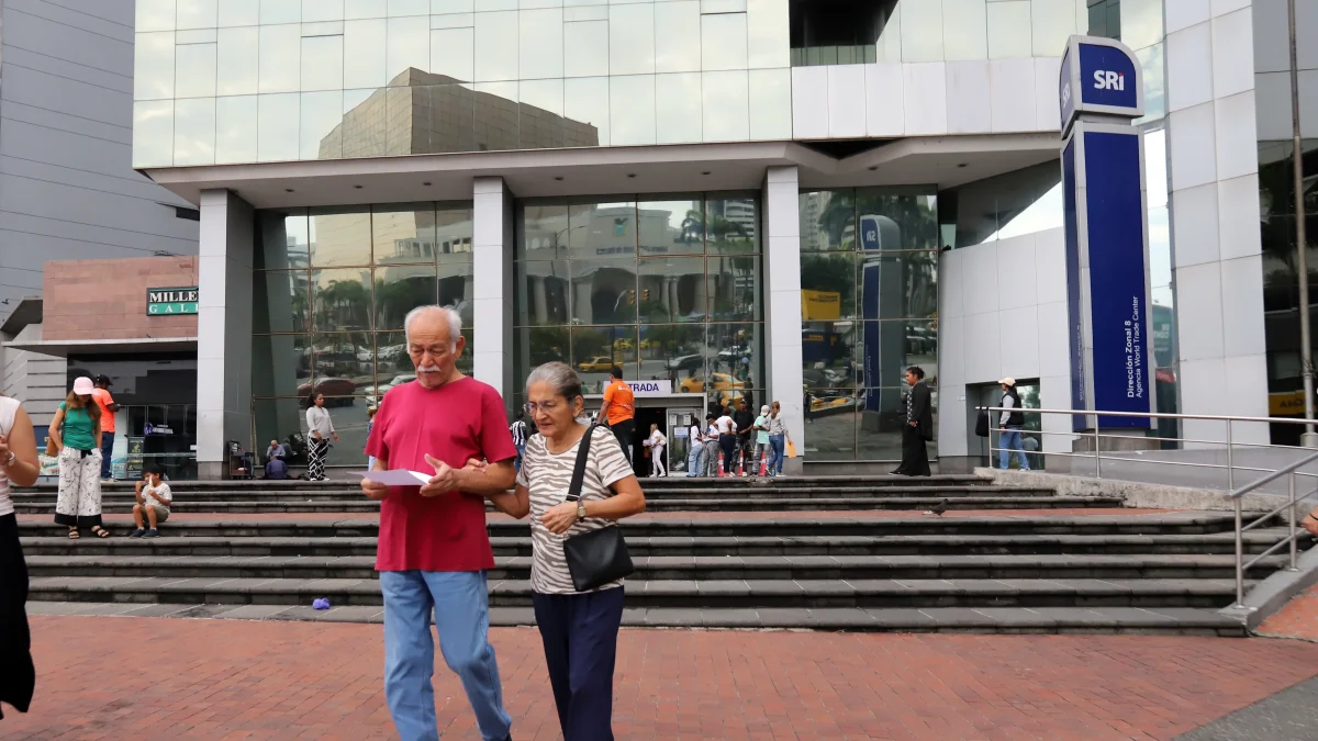Ciudadanos caminan al pie del edificio del SRI, en Guayaquil.