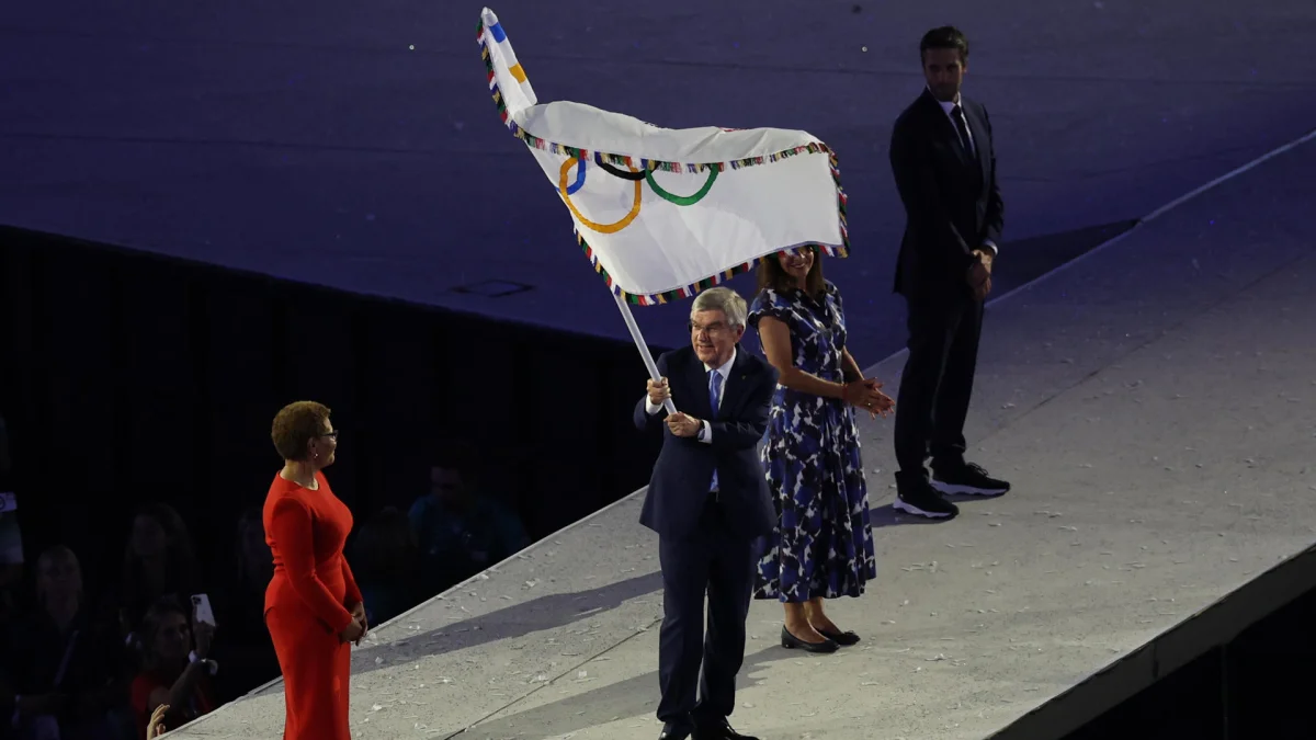 La alcaldesa de Los Angeles, Karen Bass (izq.), recibe la bandera olímpica de manos del presidente del COI, Thomas Bach (c), en foto de archivo.