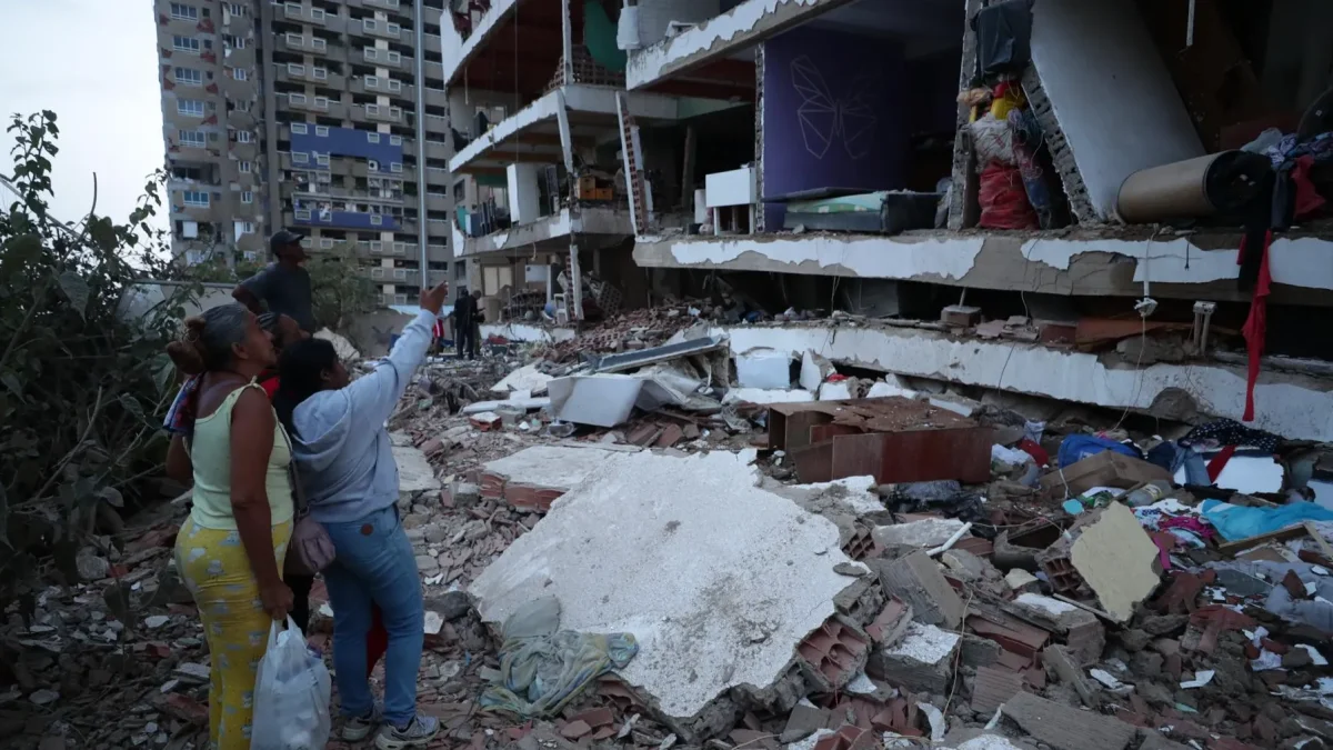 Residentes entre los escombros de uno de los bloques de viviendas dañados por los terremotos, en el estado costero de La Guaira (Venezuela) este jueves.