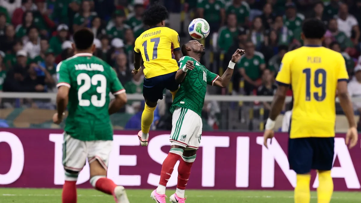 Julián Quiñones (abajo) de México disputa el balón con Angelo Preciado de Ecuador.