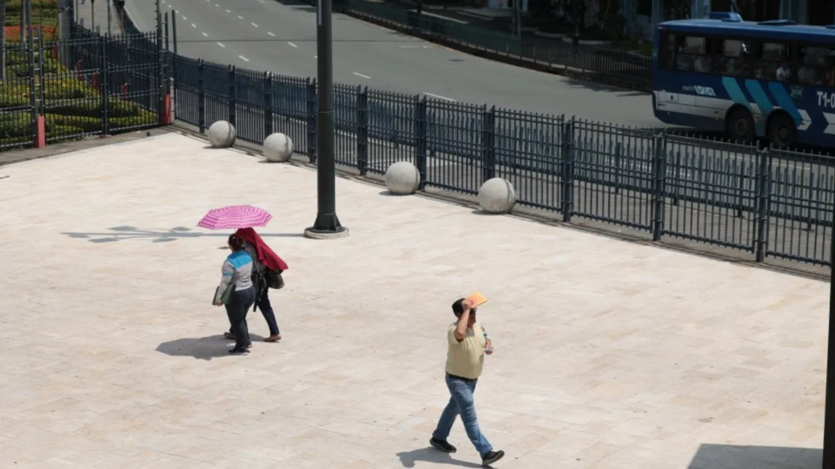 Ciudadanos en el centro de Guayaquil utilizan sombrillas y gorras para protegerse del alto índice de radiación UV que golpea a la urbe.