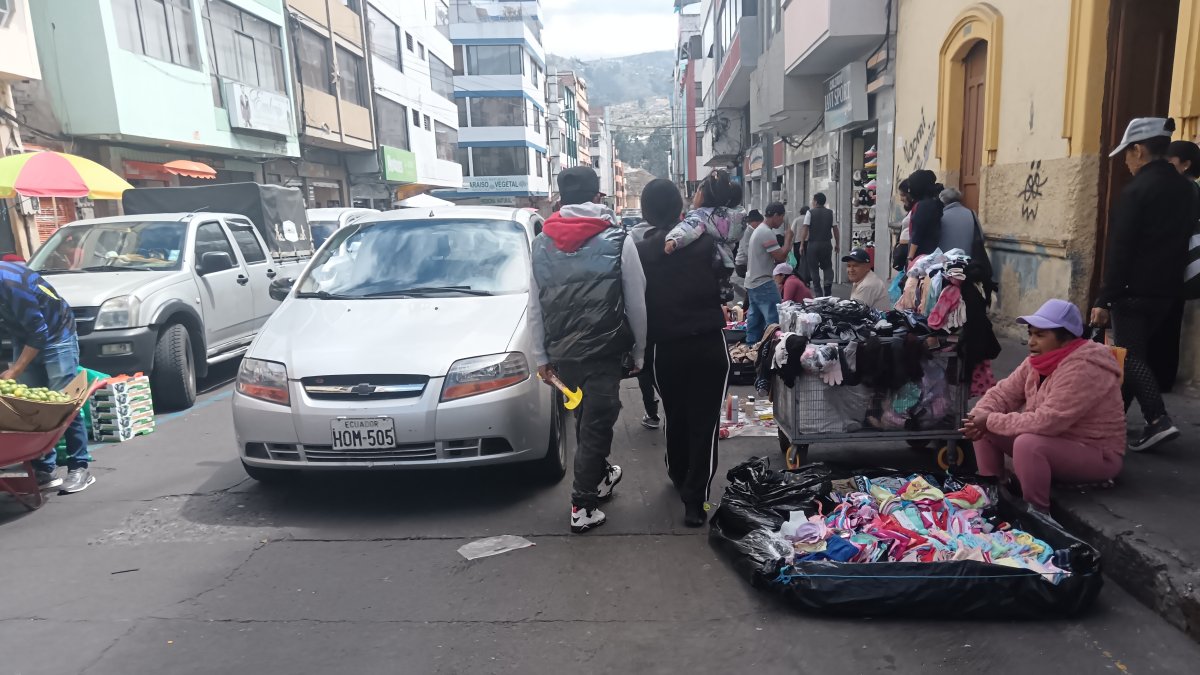 Peatones deben caminar en medio de vehículos, por reubicación de vendedores en la Plaza Primero de Mayo en Ambato.