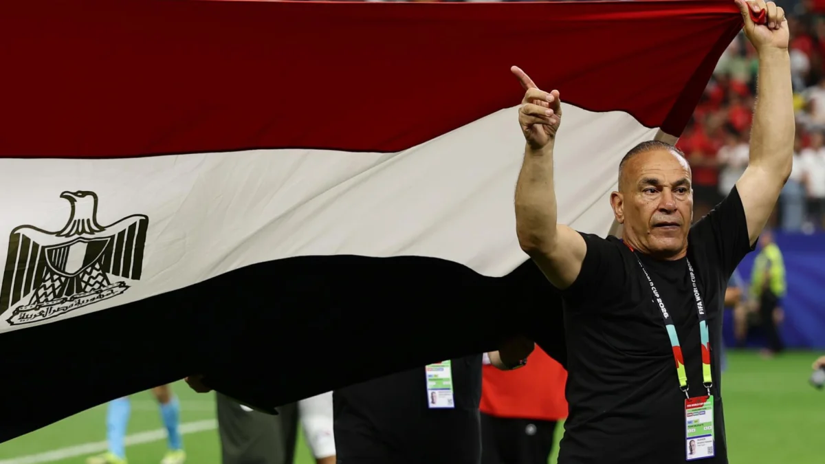 El director técnico de Egipto levanta la bandera nacional durante el partido frente a Argentina.