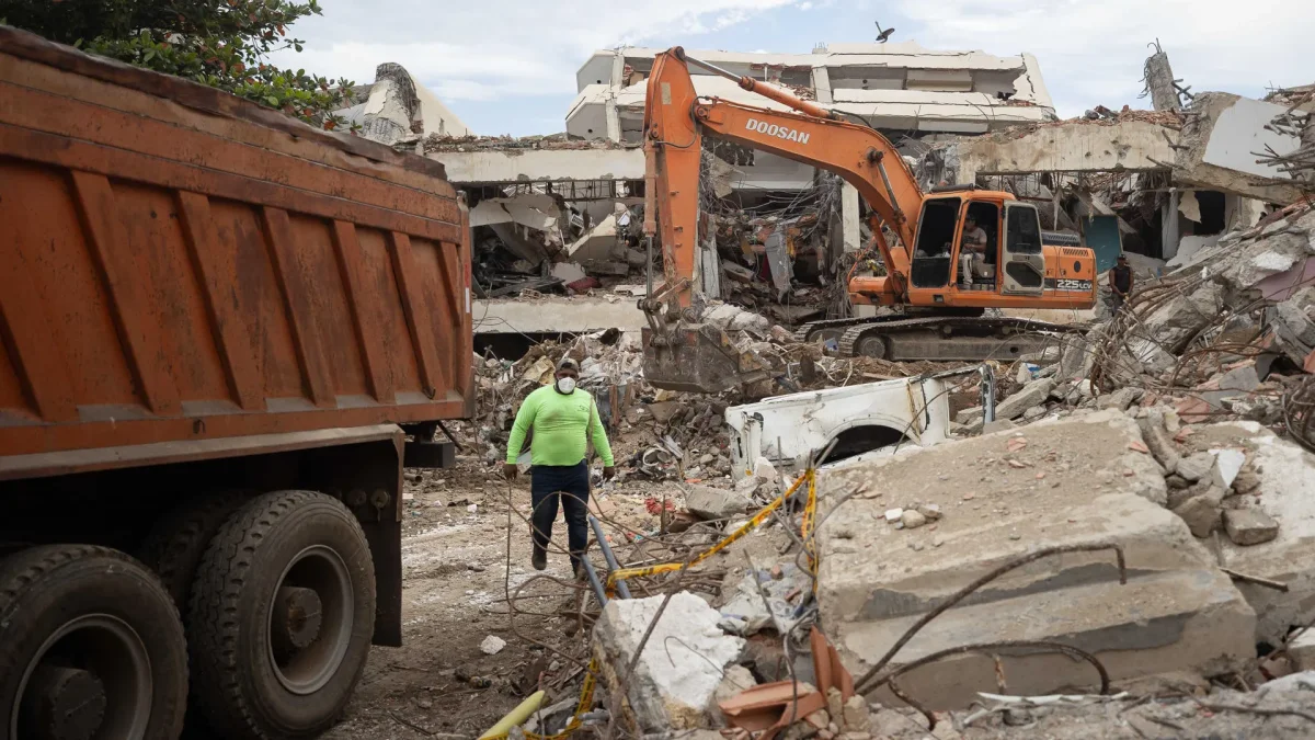 Una persona camina entre máquinas y escombros de edificios colapsados este lunes, en La Guaira (Venezuela).