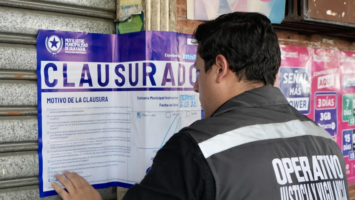 Un funcionario municipal coloca el sello de clausura en uno de los locales intervenidos durante el operativo en el sur de Guayaquil
