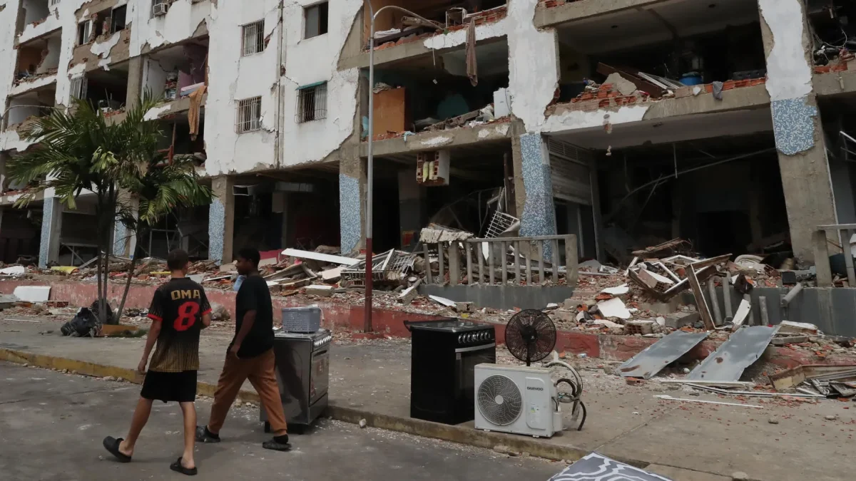 Personas caminan frente a edificios afectados por los terremotos ocurridos en la zona de Caraballeda, en La Guaira (Venezuela).