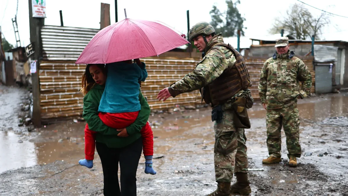 Integrantes del Ejército de Chile evacúan un campamento que presenta riesgo de inundación en la rivera del río Mapocho en Talagante (Chile).