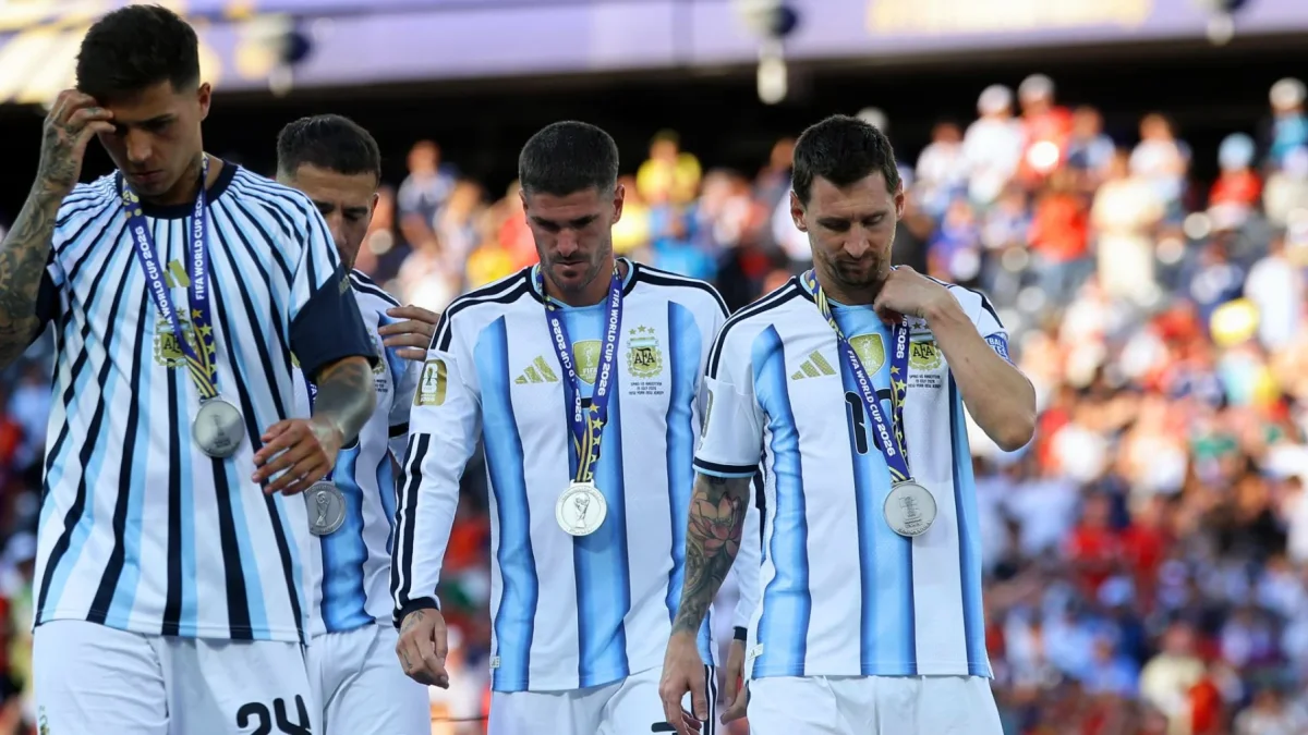 Lionel Messi (d.), Rodrigo De Paul y Enzo Fernández con las medallas de plata.