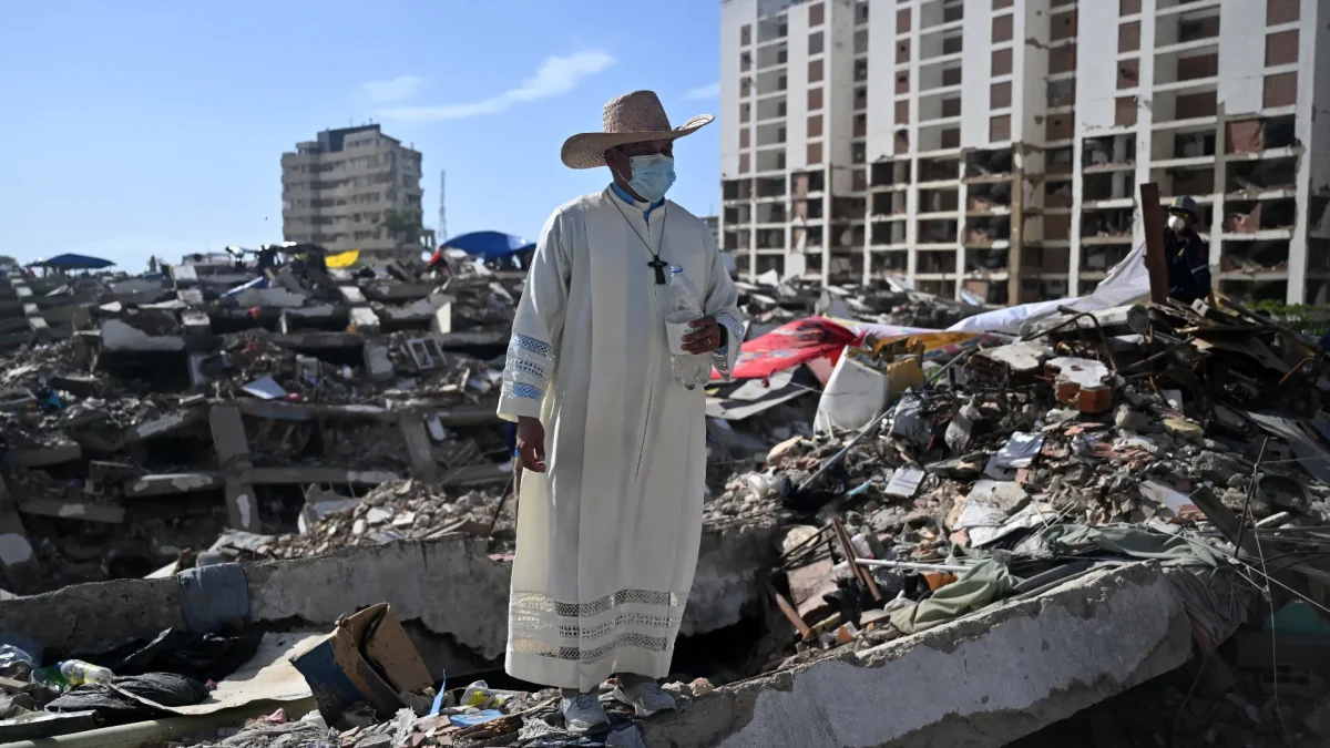 Un sacerdote permanece de pie sobre los escombros de un edificio destruido por los terremotos del 24 de junio en Caraballeda, Venezuela, el 17 de julio de 2026.
