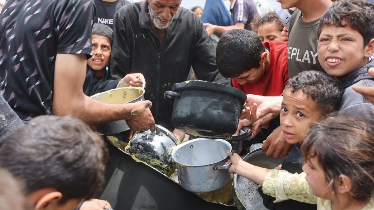 Adultos y niños buscan algo de alimenación.