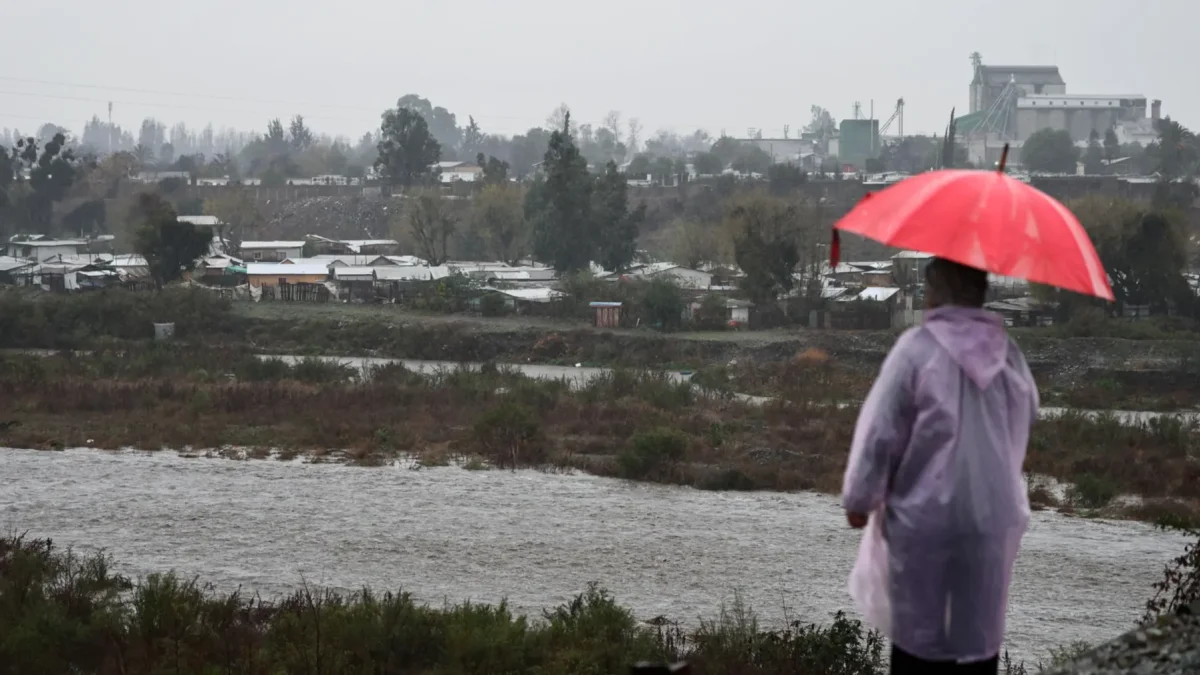 Una persona observa el caudal del Río Mapocho al costado de un campamento en riesgo de inundación en la comuna de Talagante (Chile)