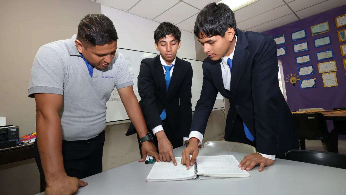 Sebastián Yépez (centro) y Leonel Vargas, del colegio Interamericano, reciben la guía del docente Jhonny Solórzano.