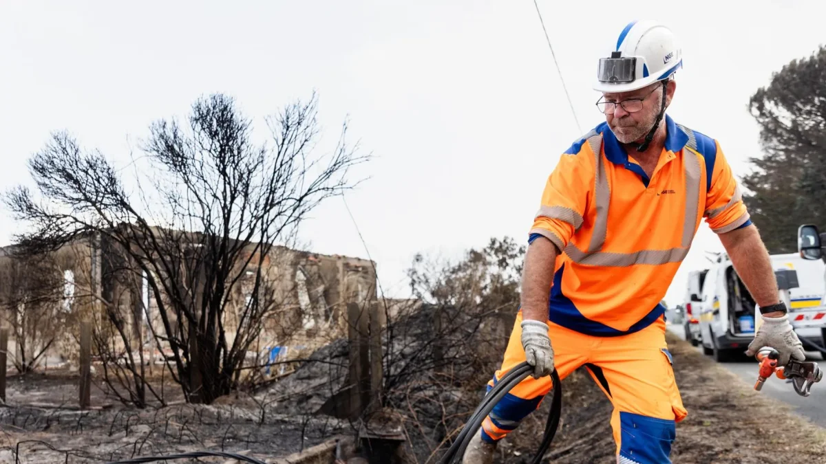 Personal de NGE Energie Solutions asegura las líneas eléctricas frente a viviendas dañadas por el fuego tras los incendios forestales en Le Porge, Francia.