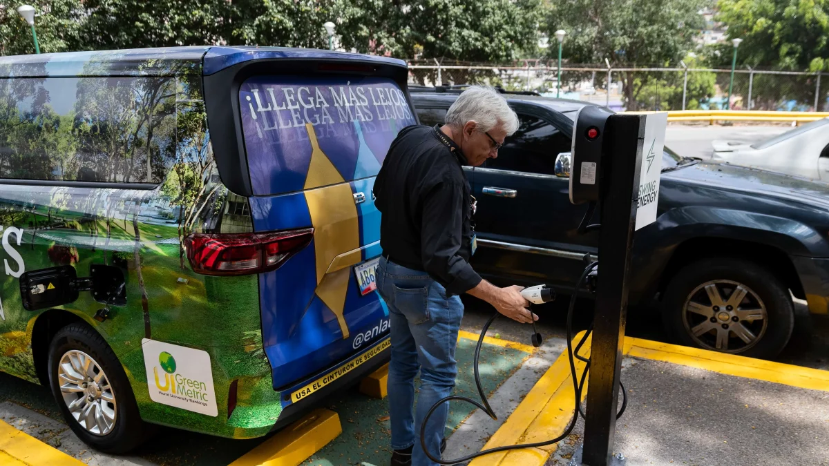 Una persona recarga su carro con electricidad, se multiplican estos puntos de carga en el mundo.