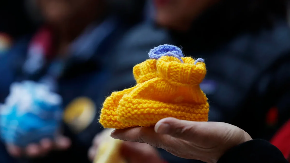 Fotografía del 9 de julio 2026 de una bota de lana para bebé, símbolo de la organización de apoyo para víctimas de adopciones forzadas y tráfico de niños en Chile.