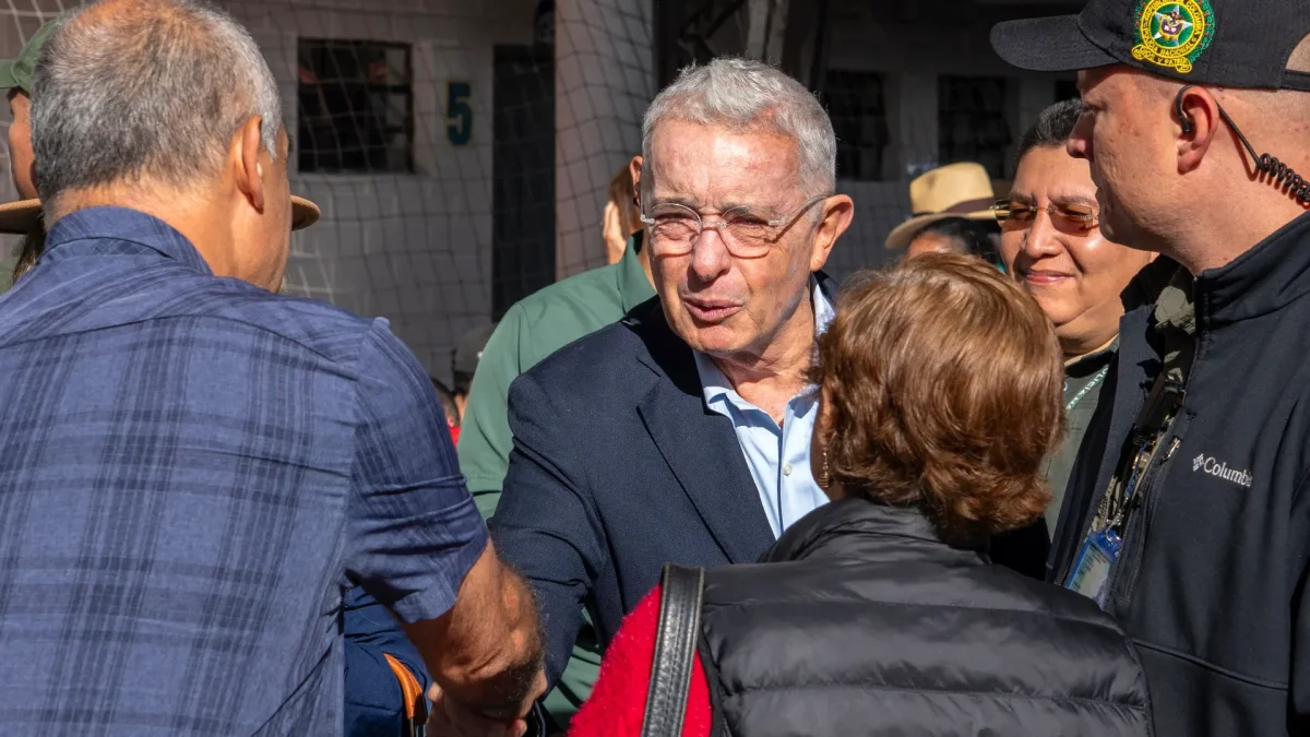 El expresidente (2002-2010), Álvaro Uribe, saluda a un simpatizante a su llegada a un colegio electoral para votar durante la segunda vuelta de las elecciones presidenciales del 21 de junio de 2026.