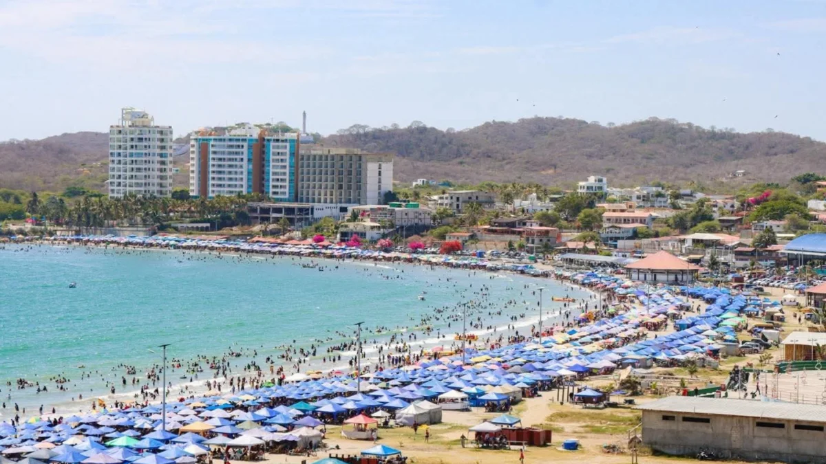 Referencial.Turistas disfrutan de la playa bajo sombrillas en la Costa ecuatoriana, mientras el Inamhi anticipa condiciones variables para el feriado.